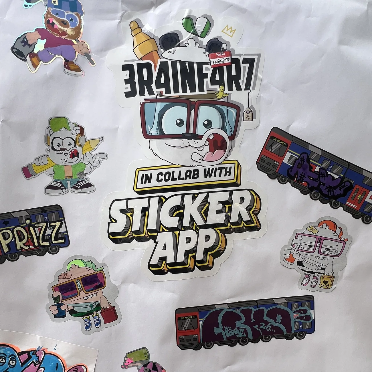 Parede coberta de autocolantes recortados Brainfart x StickerApp pintados à mão e etiquetas do comboio S8 World com tags de graffiti