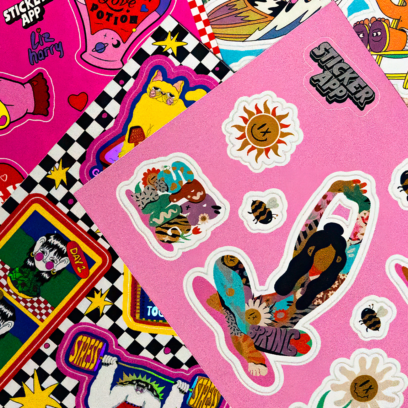 Close-up of colorful sticker sheets featuring playful illustrations and graphic designs on a pink sheet