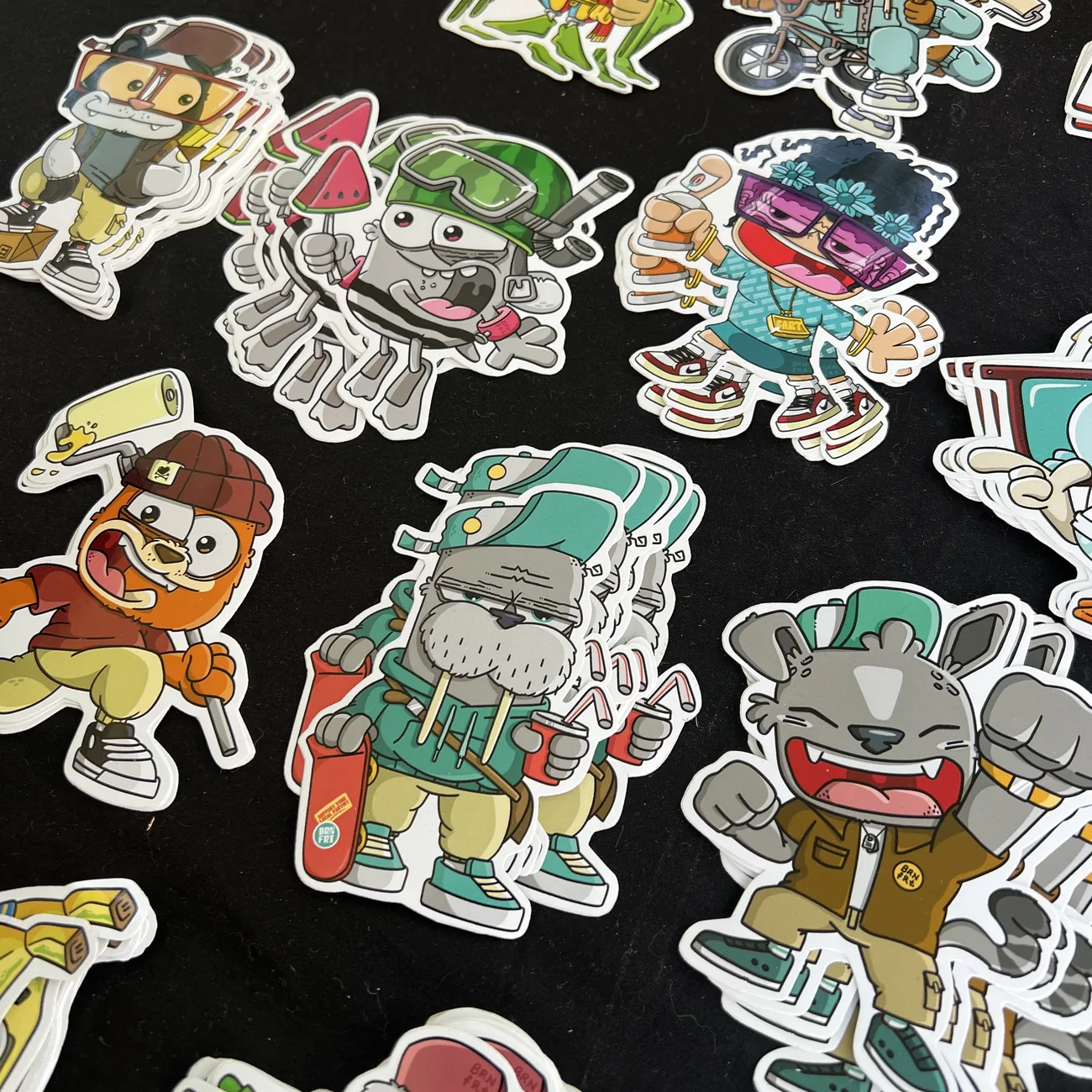 Autocolantes recortados Brainfart x StickerApp com personagens de banda desenhada em streetwear, incluindo uma morsa com skate e um gato sorridente