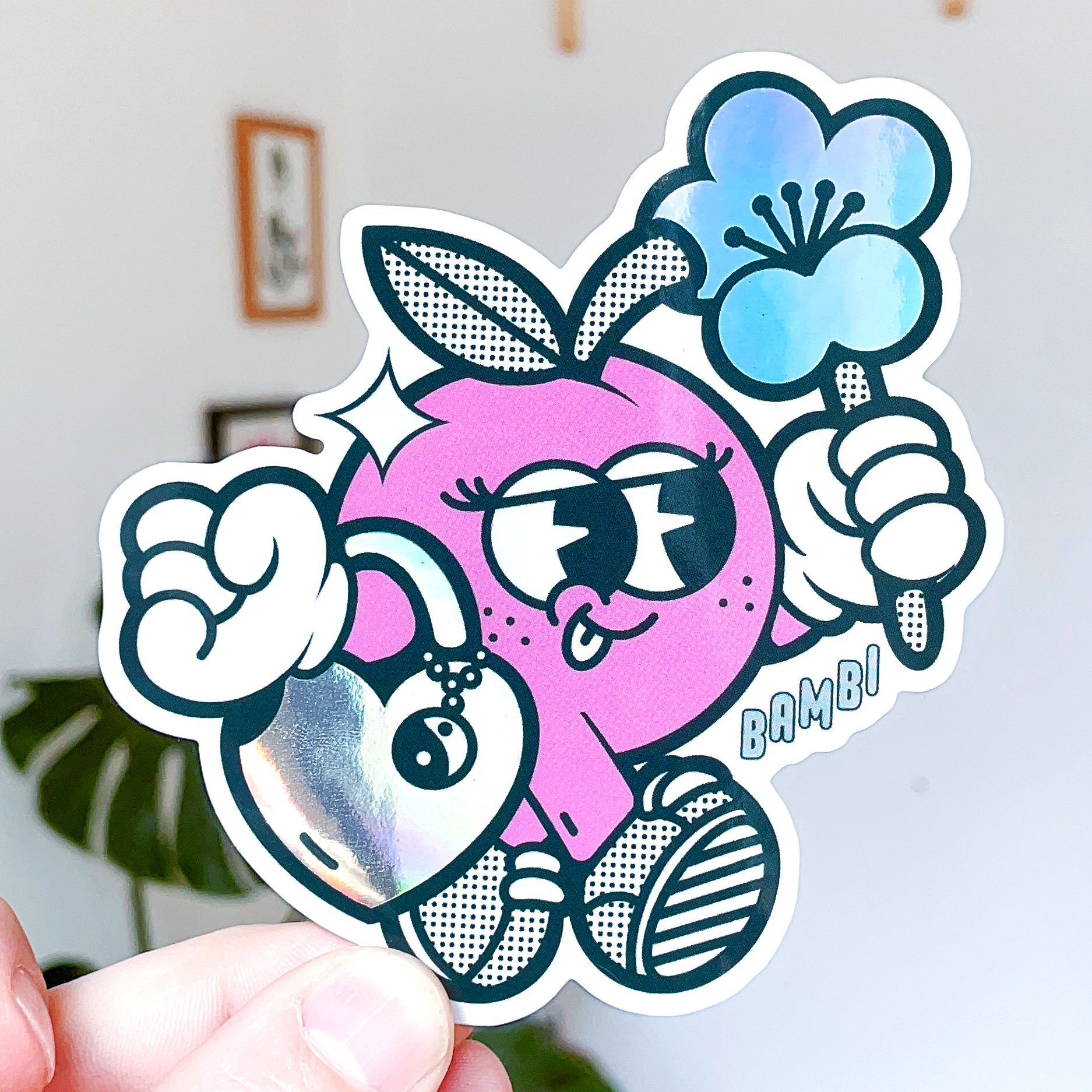 Autocolante recortado holográfico de uma personagem cor-de-rosa com uma flor azul e um coração brilhante.