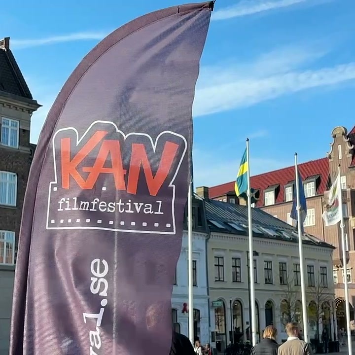 Bandeira do KAN Film Festival em frente a edifícios históricos e bandeiras numa praça de Lund