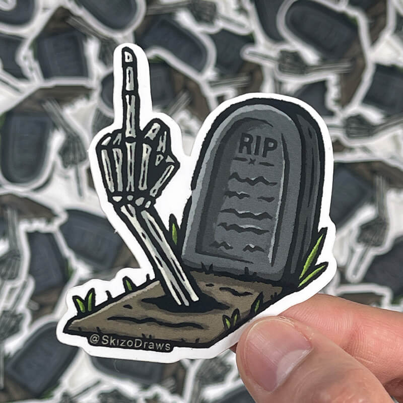 Autocolante recortado em vinil de um túmulo com o texto «RIP» e um braço de esqueleto a sair do chão a fazer o dedo do meio, sobre um fundo de autocolantes.
